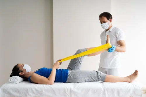 Physiotherapist+Doing+Band+Exercise+Therapy+And+Therapy+In+Face+Mask-495w
